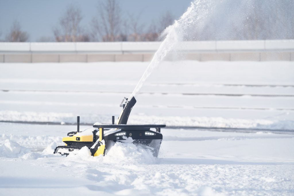 Yarbo robotgräsklippare med snöspridarmodul för effektiv snöröjning.